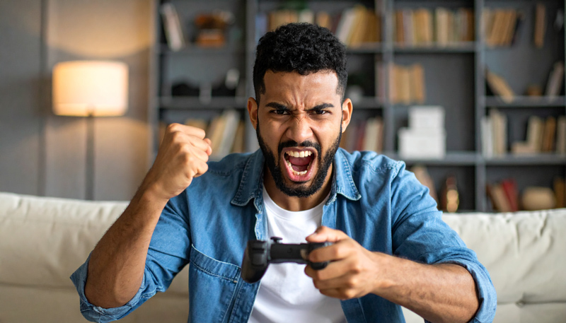 Image d'un homme qui crie et se fache en jouant à un jeu vidéo.